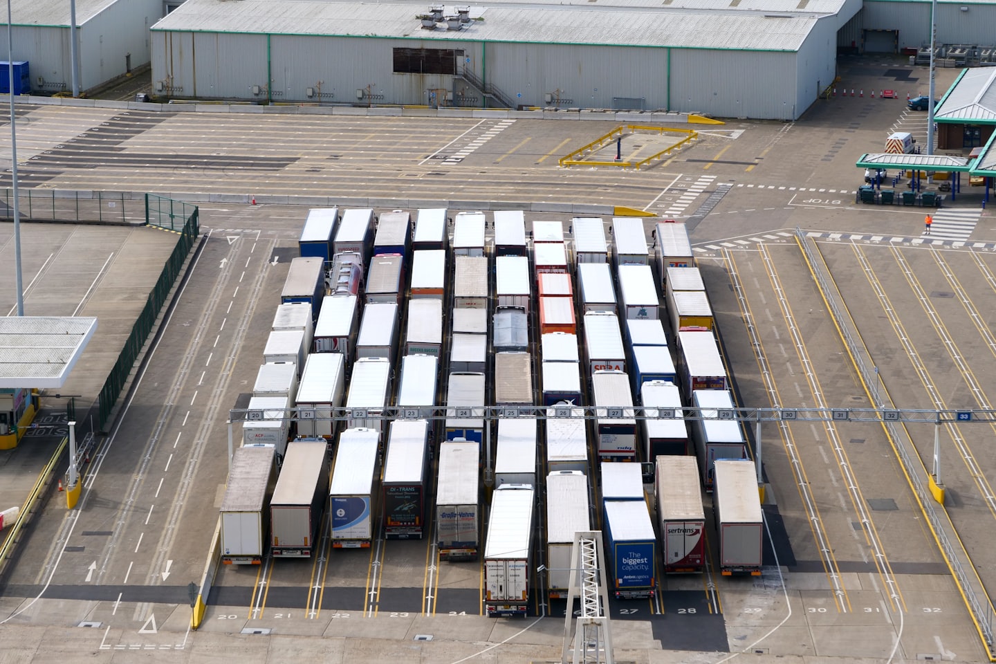Camiones tráiler estacionados en filas en una terminal logística.